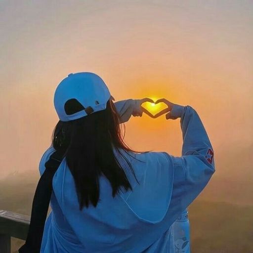 a woman in a white jacket holding a heart shaped sign