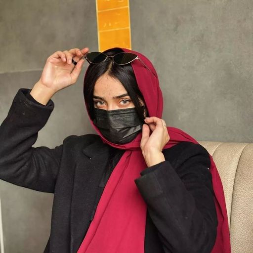 a woman wearing a black mask and a red scarf