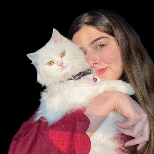 a woman holding a white cat in her arms