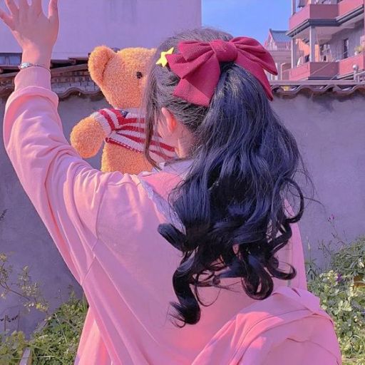 a girl in a pink shirt is holding a teddy bear