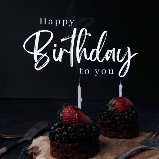 Happy birthday cupcakes with strawberries and candles on a wooden board, with the text "Happy Birthday to You" in stylish calligraphy.