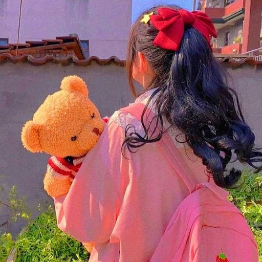 a little girl in a pink kimono holding a teddy bear