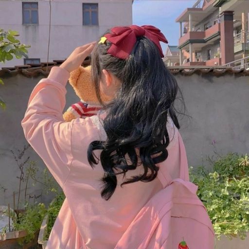 a girl in a pink dress holding a teddy bear