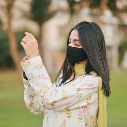 a woman wearing a face mask and looking at her cell phone