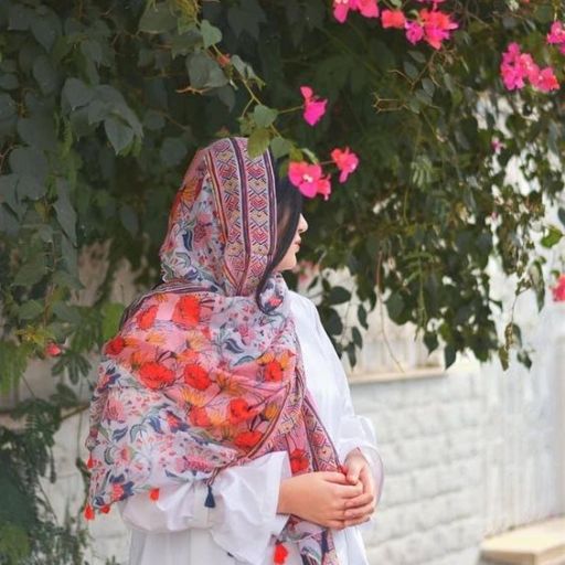 a woman standing in front of a tree with pink flowers