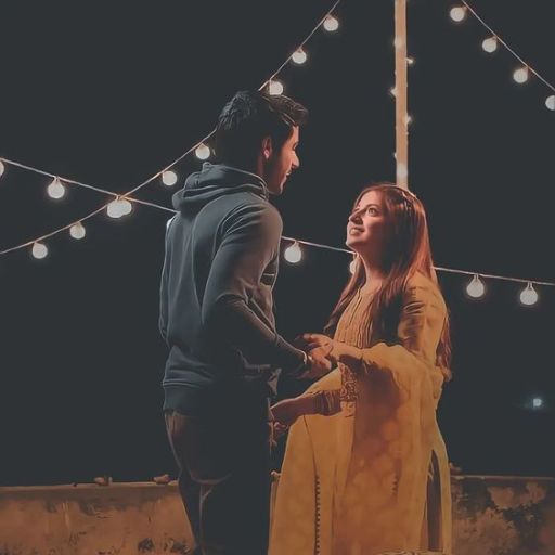 A couple standing under string lights, creating a romantic ambiance.