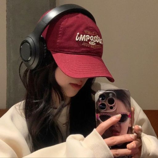 a girl wearing headphones and a cap taking a selfie