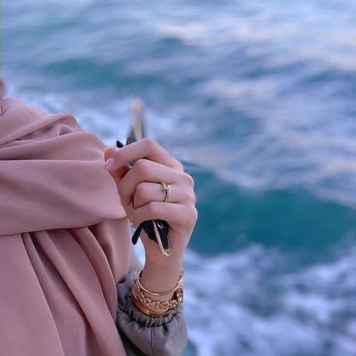 a woman in a pink hijab holding a cell phone