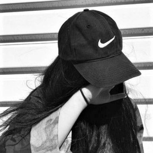 a black and white photo of a girl wearing a hat