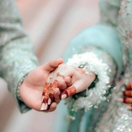 a bride and groom holding hands with their wedding rings