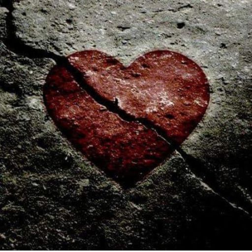 a broken heart on a rock with a knife sticking out of it