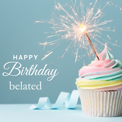 a cupcake with a sparkler on top of ita birthday card with a present on a table