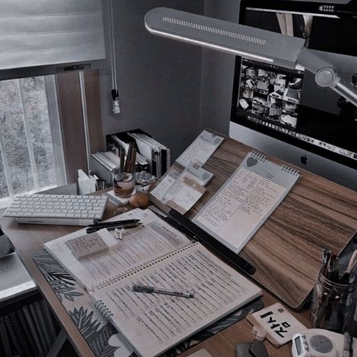 a desk with a computer, keyboard, mouse and papers on it