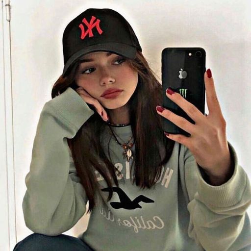 a girl in a baseball cap holding a cell phone