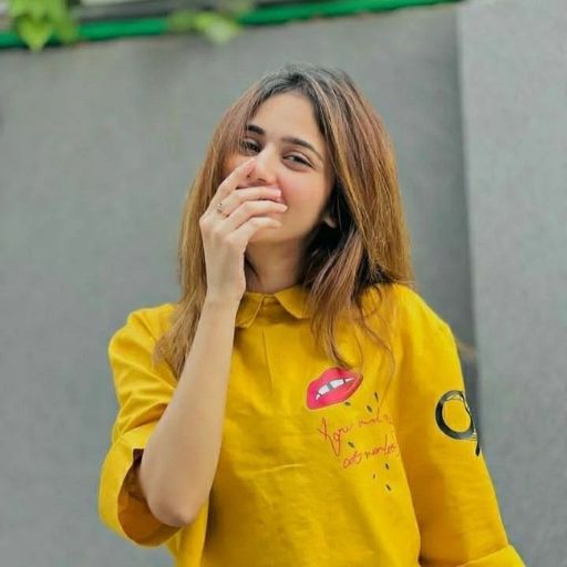 a girl in a yellow shirt covers her mouth with her hand