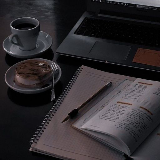 a laptop computer sitting on top of a desk next to a cup of coffee