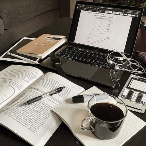 a laptop computer sitting on top of a desk next to a cup of coffee