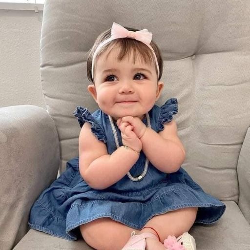 a little girl sitting on a chair smiling