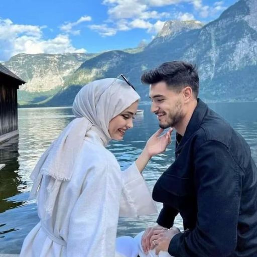 a man and a woman sitting next to each other near a body of water