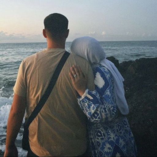 a man and a woman walking along the beach