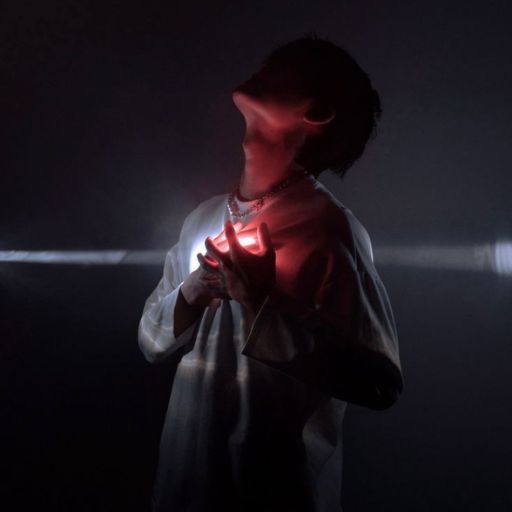 a man standing in a dark room holding a red light