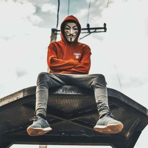 a man with a mask sitting on top of a metal structure