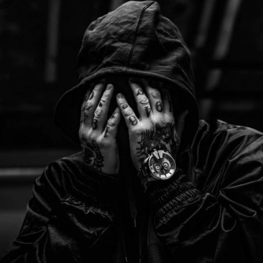 a man with tattoos covering his face with his hands