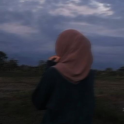 a person standing in a field with a sky in the background