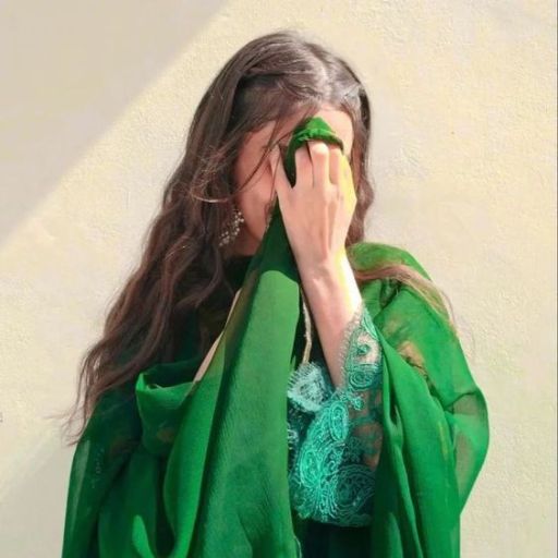 a woman covering her face with a green scarf