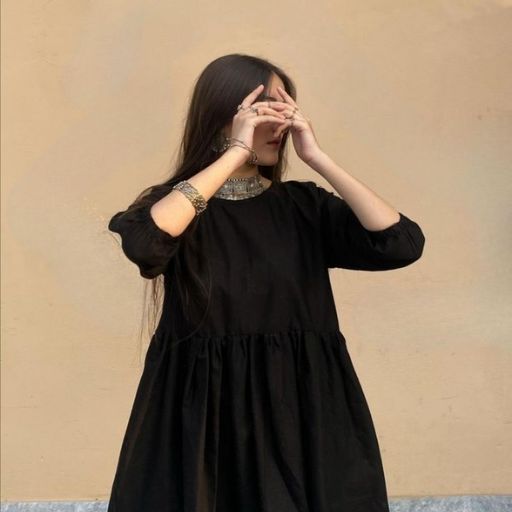 a woman in a black dress covering her eyes