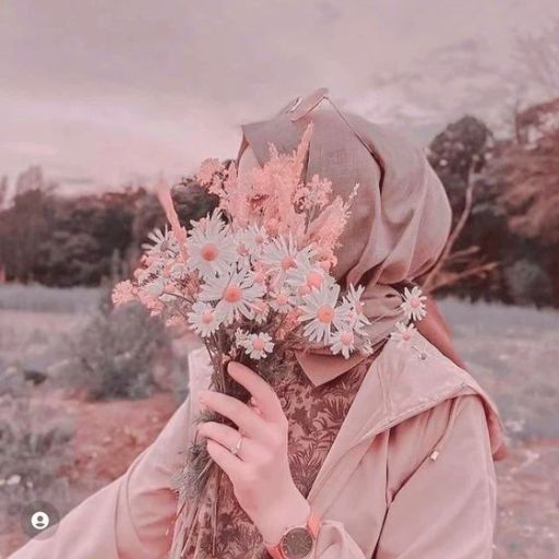 a woman in a hijab holding a bouquet of flowers