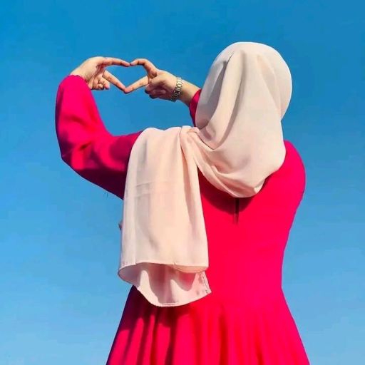 a woman in a red dress making a heart with her hands