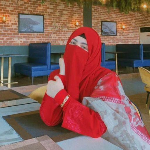 a woman in a red hijab sitting at a table