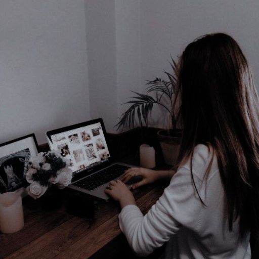 a woman sitting at a desk using a laptop computer