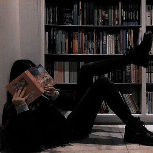 a woman sitting on the floor reading a book