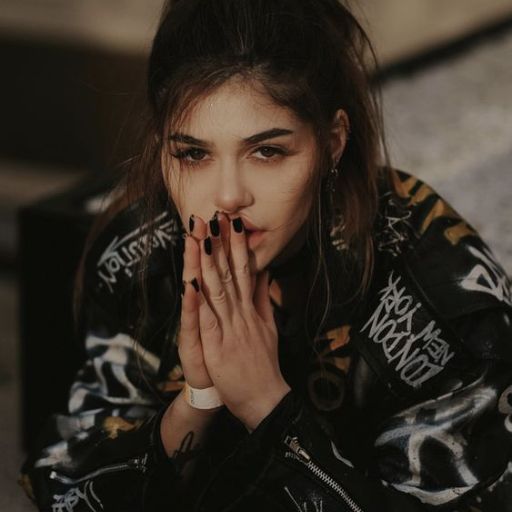 a woman sitting on the ground with her hands together