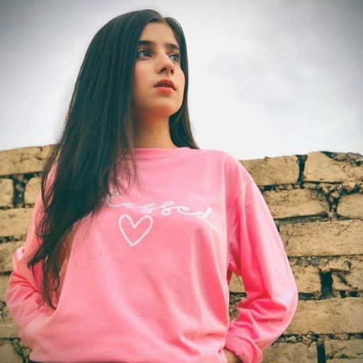 a woman standing in front of a brick wall