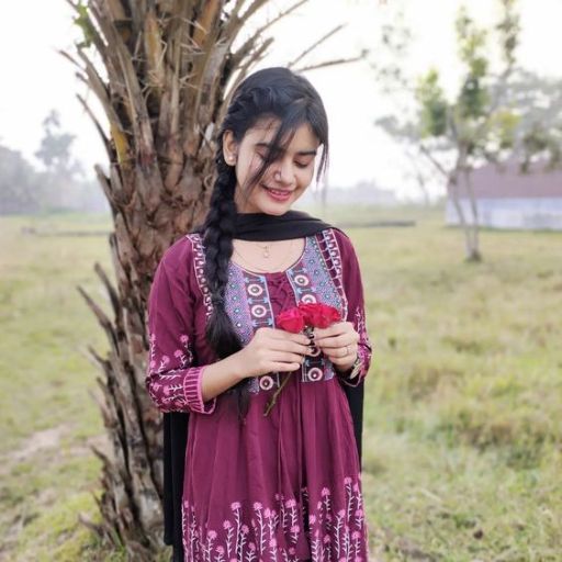 a woman standing next to a tree holding a flower