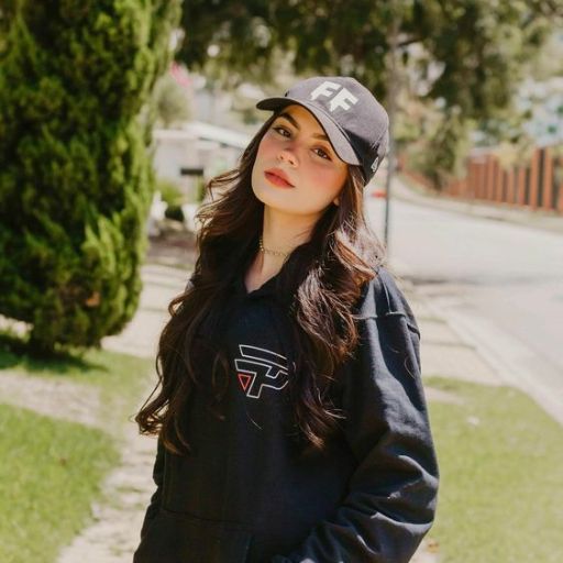 a woman standing on a sidewalk wearing a hat