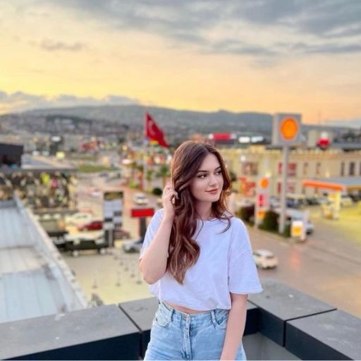 a woman standing on top of a roof talking on a cell phone