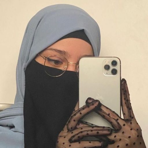 a woman wearing a hijab holding a cell phone