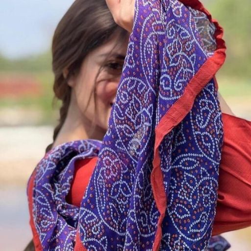 a woman wearing a red top and a blue scarf