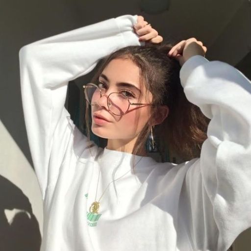 a woman wearing glasses and a white sweatshirt