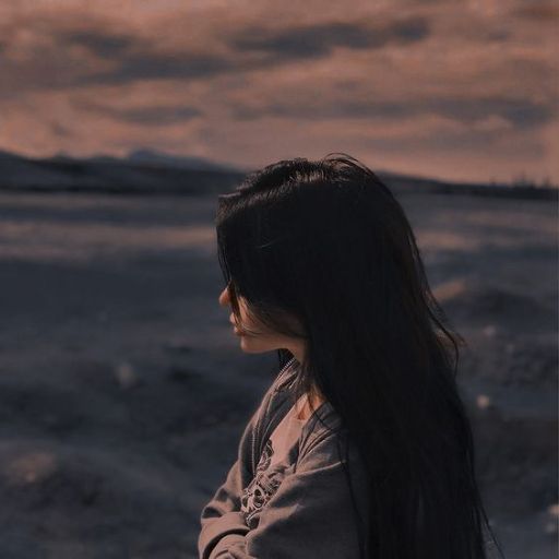 a woman with long hair standing in a field