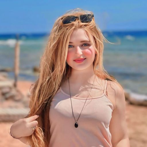 a woman with long hair standing on a beach