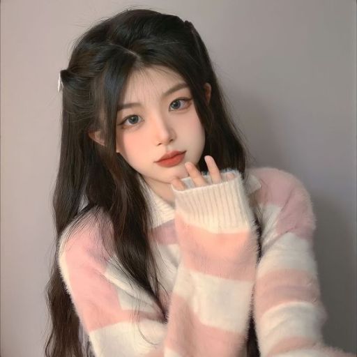 a woman with long hair wearing a pink and white sweater