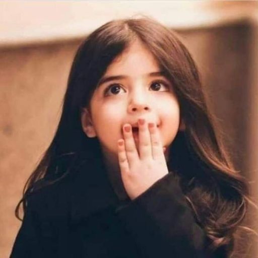 a young girl is holding her hand to her mouth