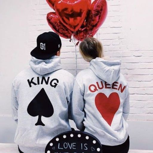 A couple in matching hoodies, one labeled _King_ and the other _Queen,_ showcasing their unity and affection