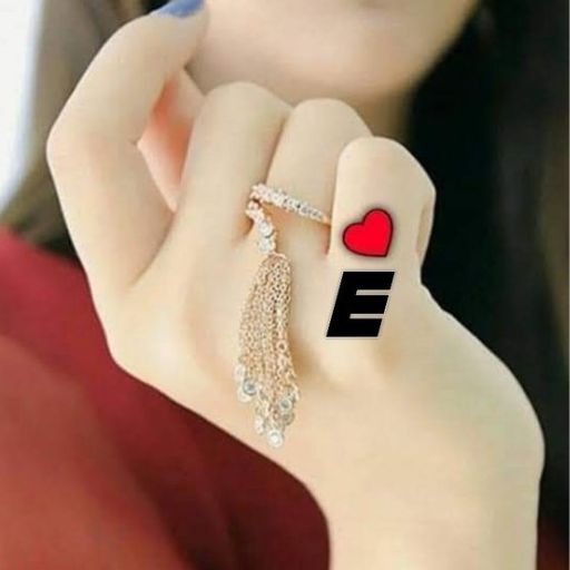 A hand with a red heart and black letter 'E' drawn on two fingers, wearing a decorative chained ring