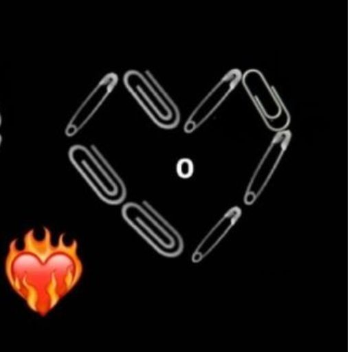 A heart shape formed by paperclips on a black background with a small flame emoji in the bottom left corner